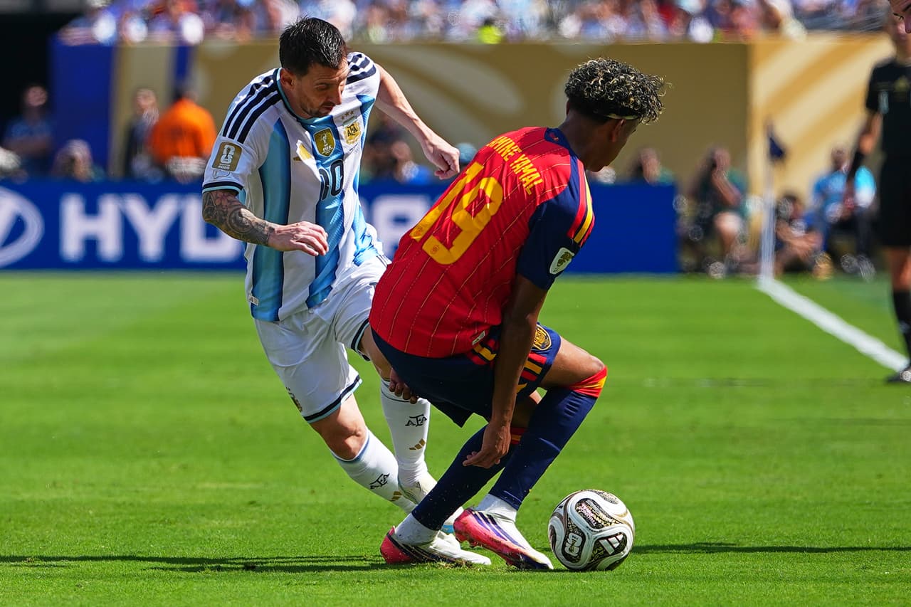 Messi y Yamal compiten por la bola.