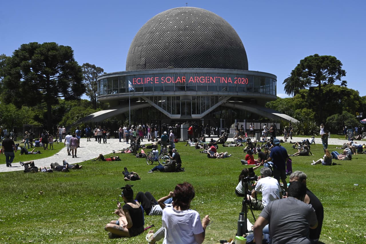 La gente observa el eclipse solar parcial frente al planetario Galileo Galilei en Buenos Aires, Argentina. El fenómeno tuvo una duración máxima de 2 minutos y 9 segundos en los lugares comprendidos por la "franja de totalidad", de unos 100 kilómetros de ancho, que incluye las localidades de Junín de los Andes, Piedra del Águila, Aluminé y Pilolil (todas en la provincia de Neuquén), y Sierra Colorada, Valcheta, Las Grutas y La Lobería, estas pertenecientes a la provincia de Río Negro.