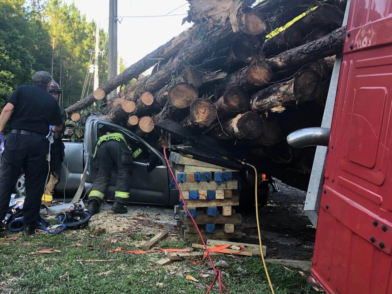 Un camión cargado con troncos se volcó y dejó a un hombre atrapado dentro de su camioneta este miércoles.
