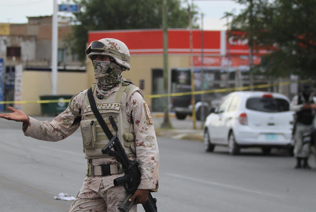 Integrantes del Ejercito Mexicano y de la Guardia Nacional resguardan una camioneta donde viajaba un familia que fue atacada con armas de fuego en Ciudad Juárez.