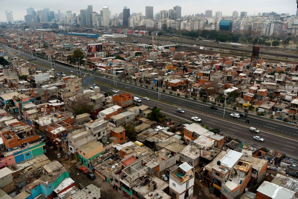 View of the Villa 31 shantytown with the upscale Recoleta neighborhood in the background in Buenos Aires, Argentina, on June 22, 2017. 40.000 inhabitants survive in the Villa 31 shantytown amid muddy streets, small brick homes without foundations and minimum basic services. The oldest shantytown in Buenos Aires, separated from exclusive neighborhoods of the capital only by an avenue, is now aiming to reach urban comfort. / AFP PHOTO / Eitan ABRAMOVICH / TO GO WITH AFP STORY BY PAULA BUSTAMANTE (Photo credit should read EITAN ABRAMOVICH/AFP/Getty Images)