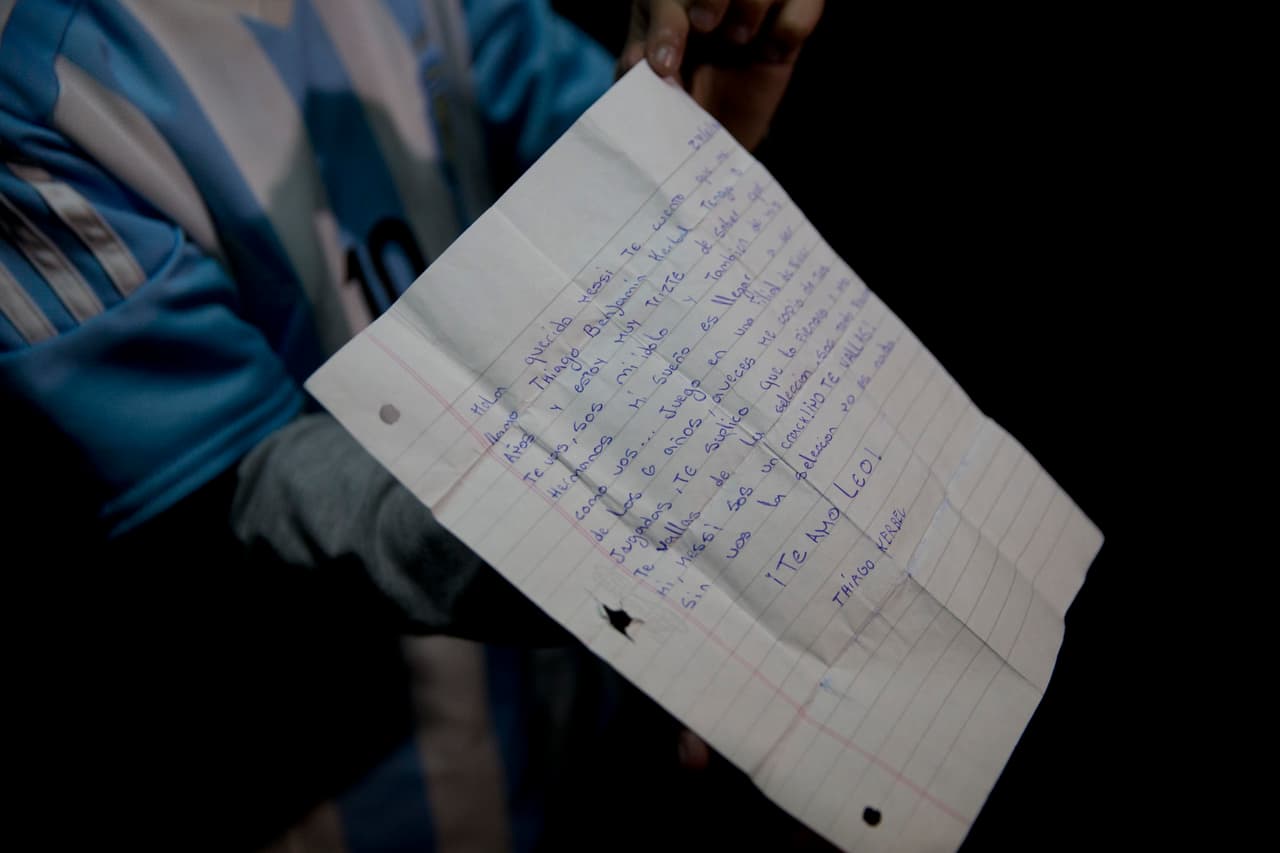 Thiago Kerbel, hincha de la selección argentina de fútbol, sostiene una carta que escribió para Lionel Messi mientras espera a la selección en el aeropuerto, el lunes 27 de junio de 2016, en Buenos Aires, Argentina. La estrella del fútbol, Lionel Messi, anunció su retiro de la selección argentina tras perder la final por tercer año consecutivo. Chile se impuso a Chile por 4-2 en la tanda de penales tras un empate 0-0 el domingo por la noche. (Foto AP/Natacha Pisarenko)
<br>
