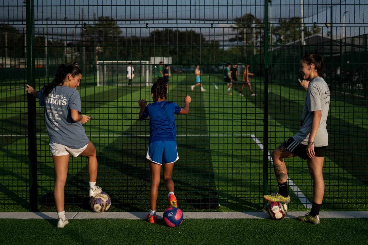 Reina Cruz y Megan Bennett dan clases privadas de fútbol. Después de las clases, ambas retoman sus prácticas en la cancha de fútbol en los alrededores de su ciudad.