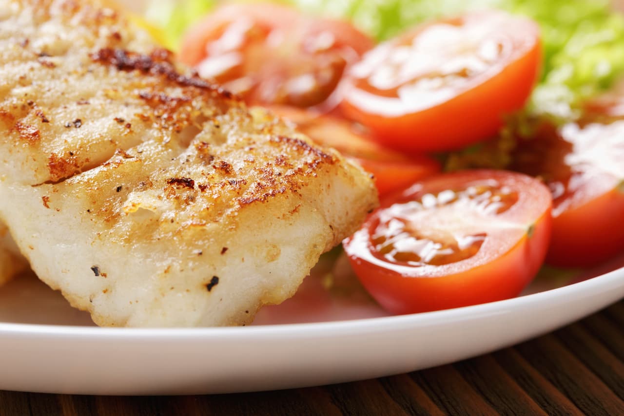 Empieza pelando y cortando las papas en rodajas finas. Lava los filetes de pescado y rocíalos con limón. Después corta las cebollas en aros finos y ralla la zanahoria, coloca las papas en una asadera para horno, salpimentamos y coloca un poco de aceite.