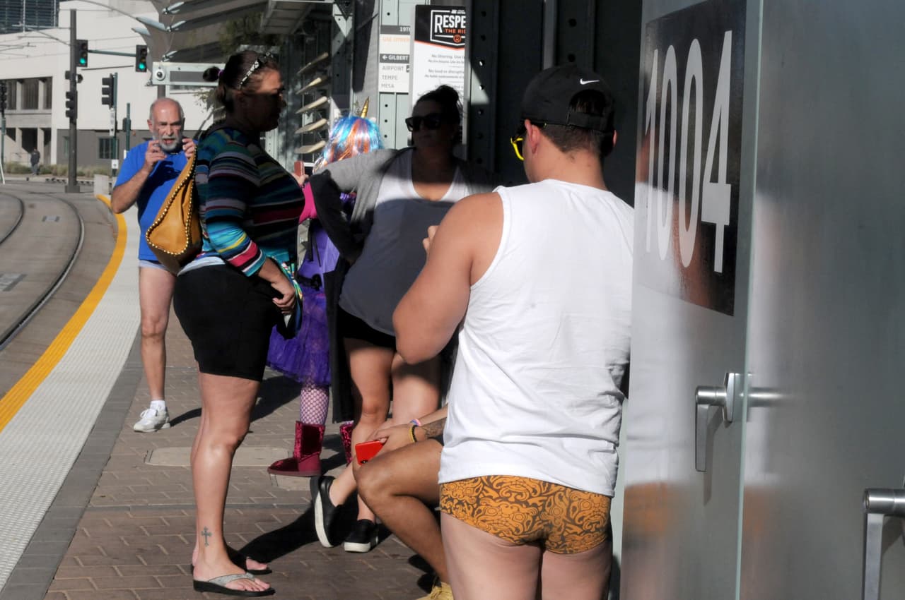 Para la ocasión, participantes de todas las edades se congregan en las plazas públicas o estaciones de Metro más concurridas de las ciudades para realizar el viaje sin pantalones. En la fotografía se ve a la gente esperando el Metro en ropa interior en Phoenix, Arizona.
<br>