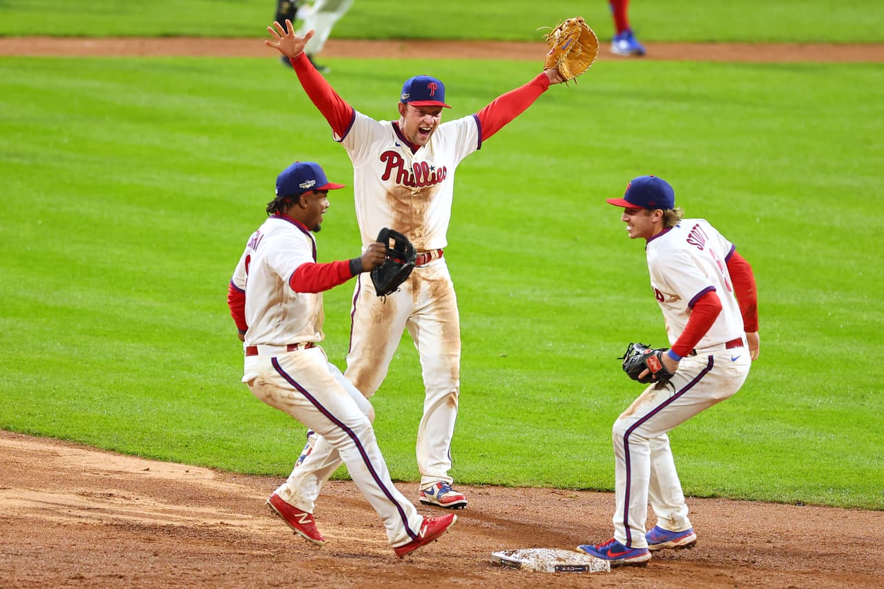Jean Segura #2, Bryson Stott #5 y Rhys Hoskins #17 reaccionan después de derrotar a los Padres de San Diego.