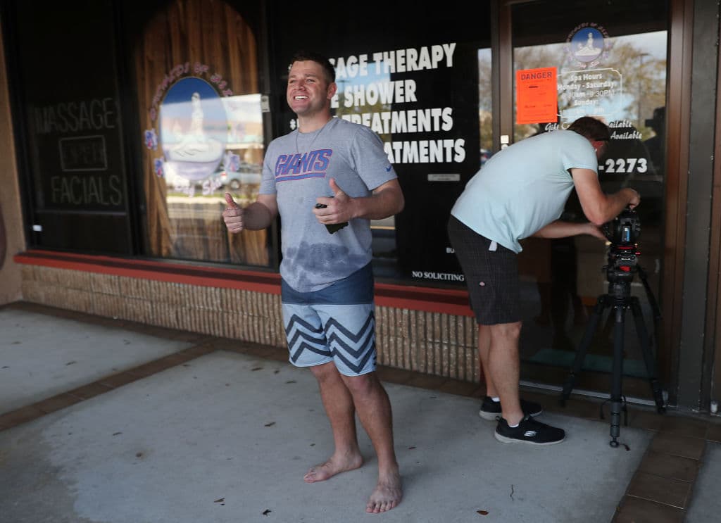 Un fanático de los New York Giants posa con los pulgares en alto afuera del spa Orchids of Asia en Jupiter, Florida.