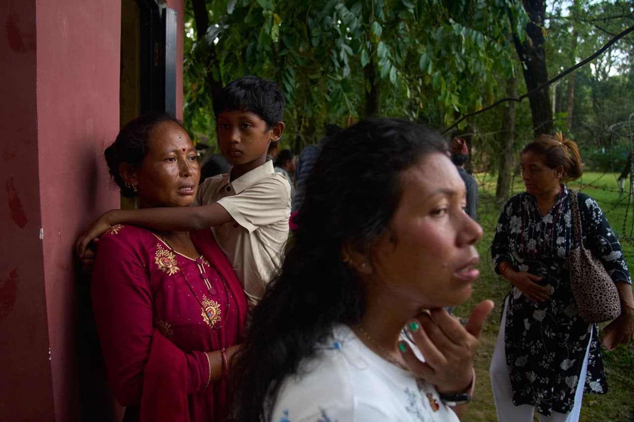 Personas esperan noticias de sus familiares desaparecidos tras las inundaciones repentinas.