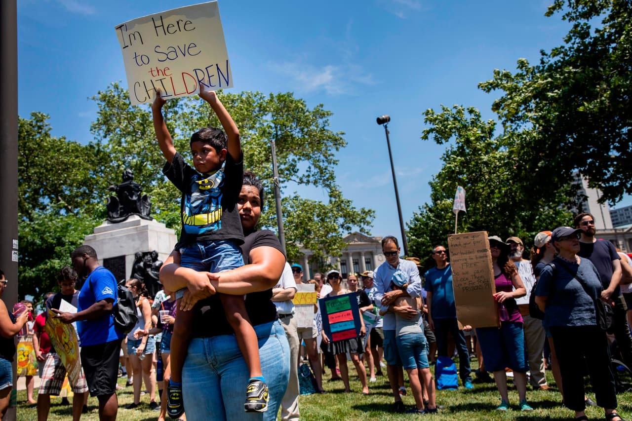"Estoy aquí para salvar a los niños", señala este letrero sostenido por un niño en brazos de su madre en la manifestación de Pensilvania (Dominick Reuter /AFP / Getty Images)