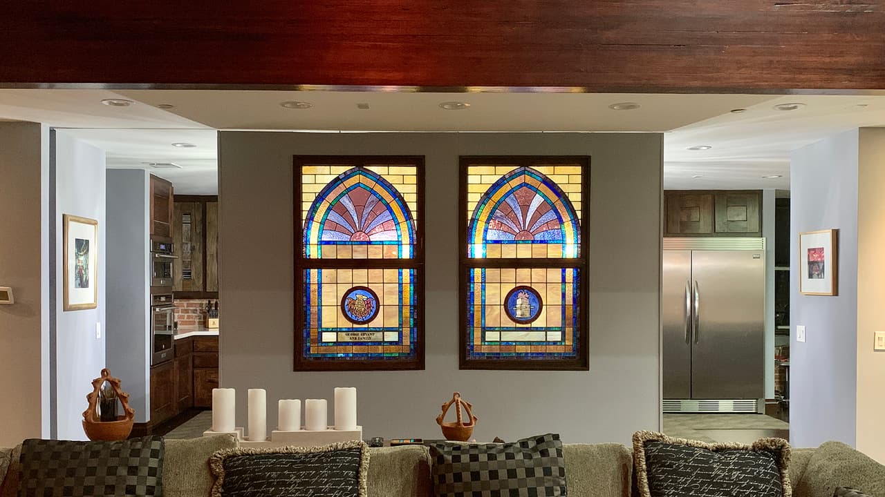 Los vitrales originales de la iglesia se agregaron al diseño interior. Aquí una pared corrediza separa la sala de la cocina.