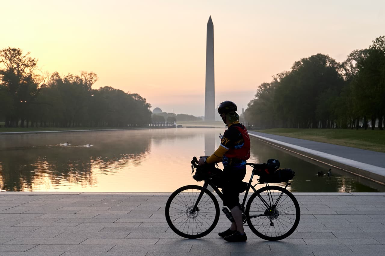 Un ciclista en el monumento a Abraham Lincoln ve hacia el obelisco de la capital estadounidense que honra a George Washington.