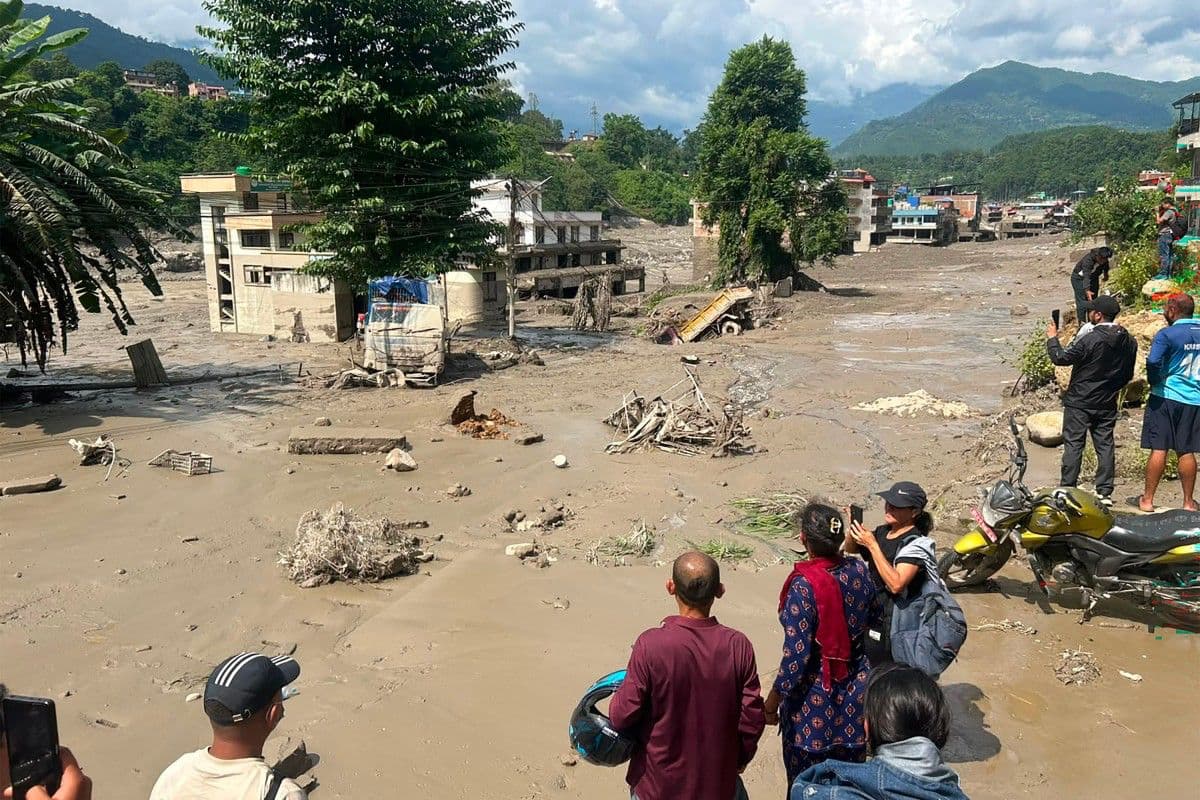 Los residentes observan las casas parcialmente sumergidas en agua lodosa tras las inundaciones repentinas en Trishuli Bazar, en el distrito de Nuwakot, Nepal.
