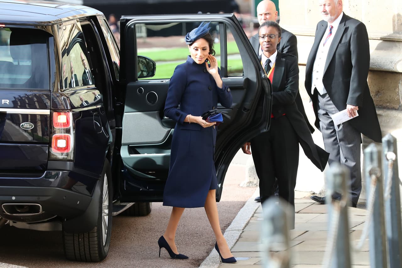 La duquesa de Sussex, Meghan Markle, llegó con un abrigo azul marino de Givenchy, adecuado pero no impactante.