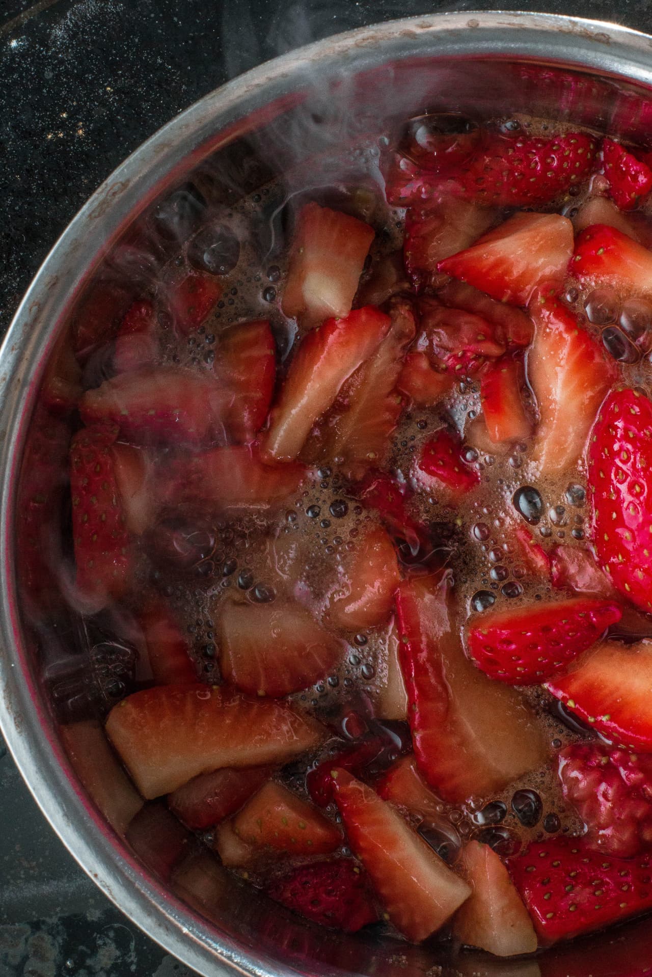 Primero debes poner a reposar las fresas cortadas en agua y agrégales el azúcar. Cuando ya hayan soltado su jugo añade el chorrito de jugo de limón y lleva a cocción, la cual debe ser a fuego alto al principio. Después de que comience a hervir baja el fuego al mínimo y deja cocer por una hora o hasta que las burbujas de la ebullición sean lentas.