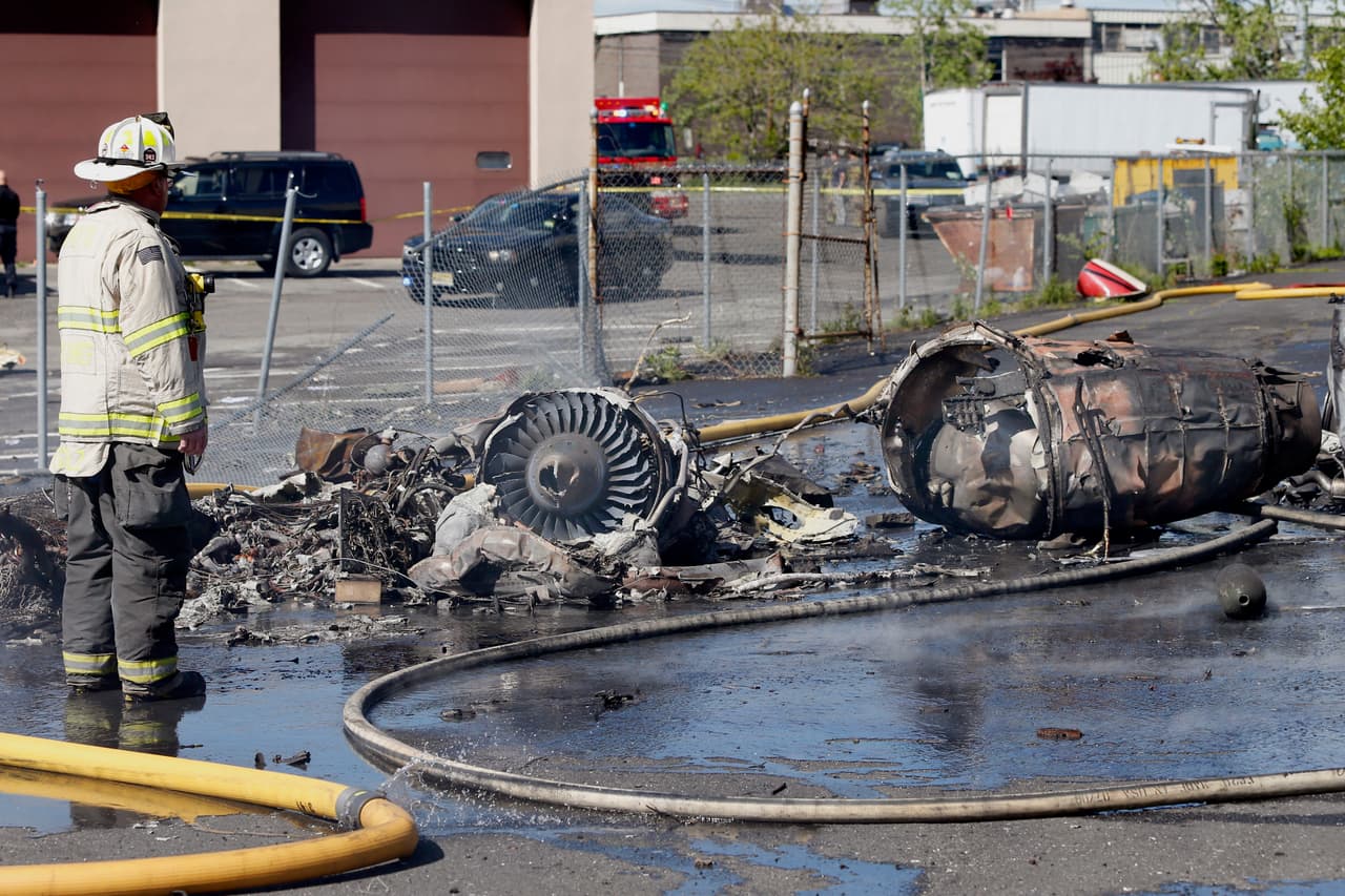 Un bombero trabaja en el lugar del accidente, ocurrido cuando la avioneta se aproximaba al aeropuerto de Teterboro.