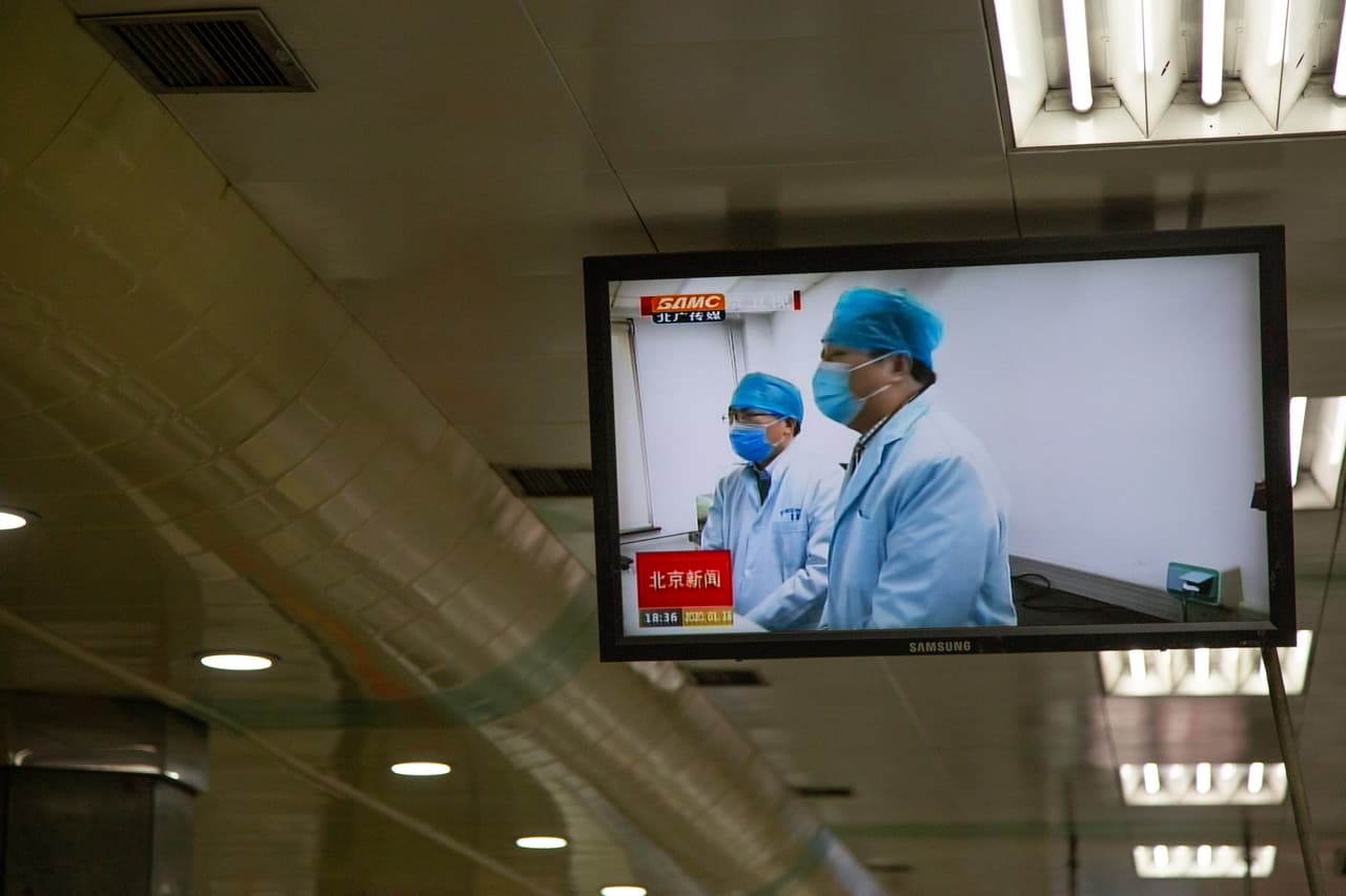 En las estaciones de metro de Pekín se muestran videos de médicos con máscaras para protegerse del coronavirus.