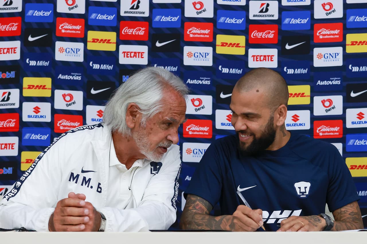 Dani Alves firmando su contrato de un año con Pumas junto al ingeniero Leopoldo Silva, presidente de la junta directiva, y Miguel Mejía Barón, vicepresidente deportivo.