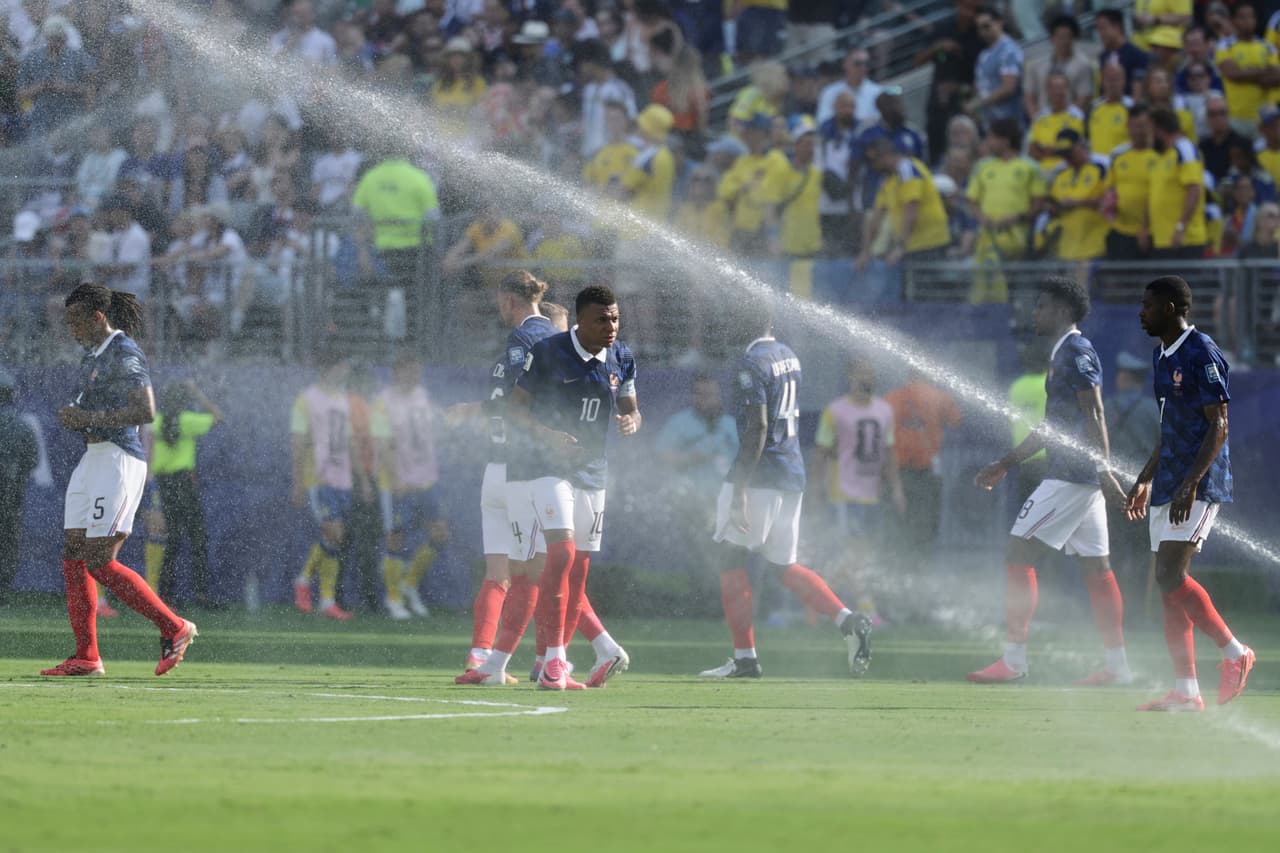 El francés Kylian Mbappé (10) y sus compañeros de equipo caminan entre los aspersores durante una pausa de hidratación en el partido de la ronda de 32 de la Copa del Mundo entre Francia y Suecia, en East Rutherford, Nueva Jersey —cerca de Nueva York—, el martes 30 de junio de 2026.
