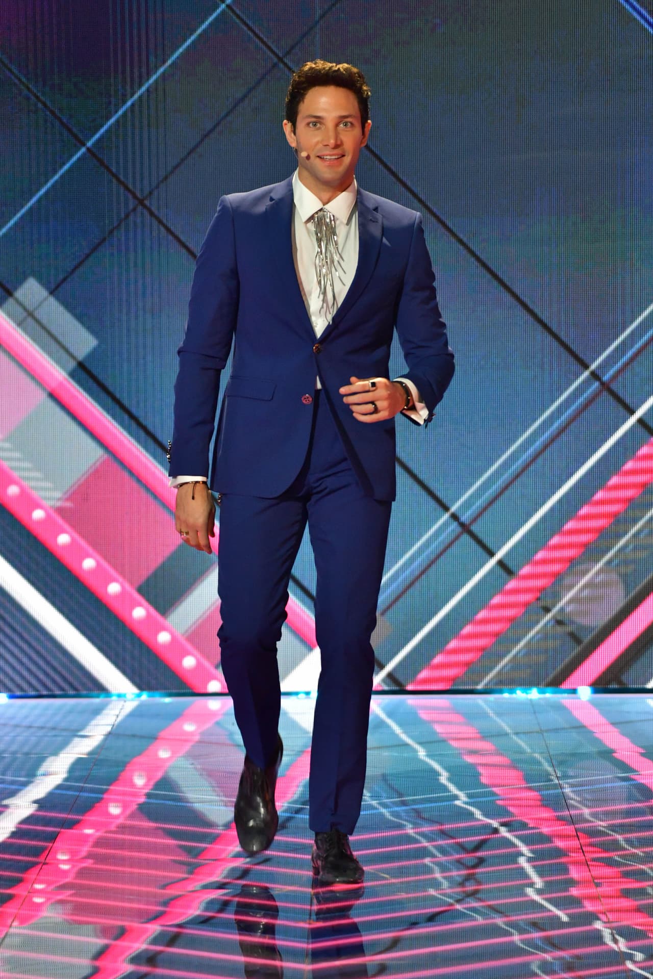 <b>Gabriel Coronel</b> lució muy elegante con un traje azul, camisa blanca y un adorno plateado que sustituyó la corbata. Fue un diseño fresco que fue obra del diseñador de imagen Emilio Uribe.