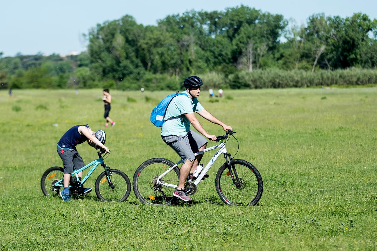 Un hombre y un niño pasean en bicicleta en el parque Caffarella de Roma, el 4 de mayo de 2020. Italia comenzó a suavizar algunas restricciones para contener el coronavirus.