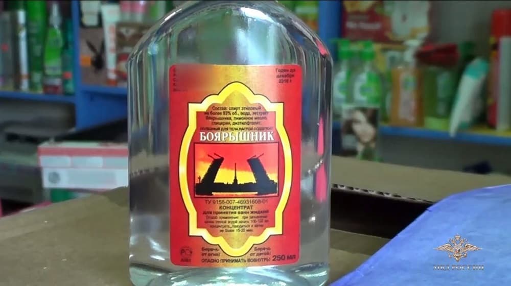 Fotografía facilitada por el Ministerio ruso de Interior que muestra una captura de vídeo en la que aparece un agente de policía mientras registra una botella de loción de baño confiscada durante una operación policial en una tienda de Irkutsk, Rusia.