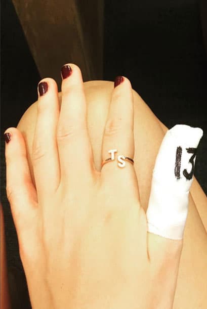 ¡Bellísimo el anillo de oro con pedrería y las iniciales de Taylor Swif, una lástima que se haya lastimado uno de sus deditos!