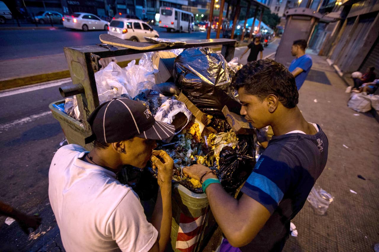 <b>No hay comida para todos. </b>Con la producción de alimentos totalmente controlada por el Estado, desde la importación, cultivos, manufactura y distribución de comida, varias organizaciones han denunciado la falta de alimentos disponibles para la población.
<b><a href="http://www.univision.com/noticias/crisis-en-venezuela/no-eramos-ricos-pero-comiamos-asi-es-vivir-con-hambre-en-venezuela"> Según una investigación de More Consulting, 88.9% de los consultados declaró que temía quedarse sin comida, 53.9% señaló que se acostó con hambre por falta de alimentos en su hogar</a></b>
<a href="http://www.univision.com/noticias/crisis-en-venezuela/no-eramos-ricos-pero-comiamos-asi-es-vivir-con-hambre-en-venezuela">,</a> y 57.8% contestó que “ha dejado de comer para darle comida a sus hijos”. Según otro estudio realizado por universidades venezolanas, un 68,3% de los venezolanos ha tenido que pedir dinero prestado para comprar comida, un 30% ha recibido alimentos regalados,
<b><a href="http://www.univision.com/noticias/america-latina/en-fotos-la-solidaridad-de-los-venezolanos-con-los-que-no-tienen-para-comer-fotos">un 8% reconoce haber comido de la basura</a></b> y un 5% haber mendigado. En la foto, venezolanos buscan comida en un contenedor de basura en Caracas. Marzo 2017.