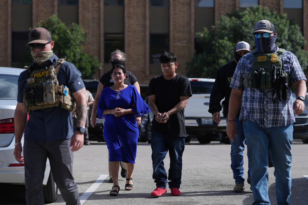 <b>Agentes federales escoltan a una familia hasta un autobús de transporte</b> tras ser detenidos tras comparecer ante un tribunal de inmigración.