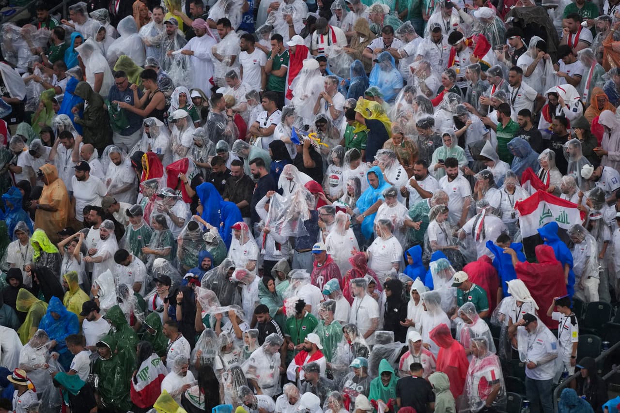 Unos aficionados llevan puestos ponchos para protegerse de la lluvia durante el partido de fútbol del Grupo I de la Copa del Mundo entre Francia e Irak en Filadelfia, el lunes 22 de junio de 2026.