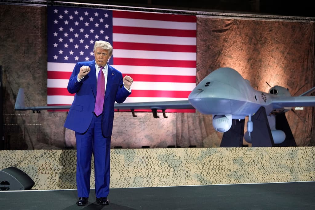 Donald Trump hace uno de sus típicos gestos frente a un dron MQ-9 Reaper, en la base aérea de Al Udeid, en Catar.