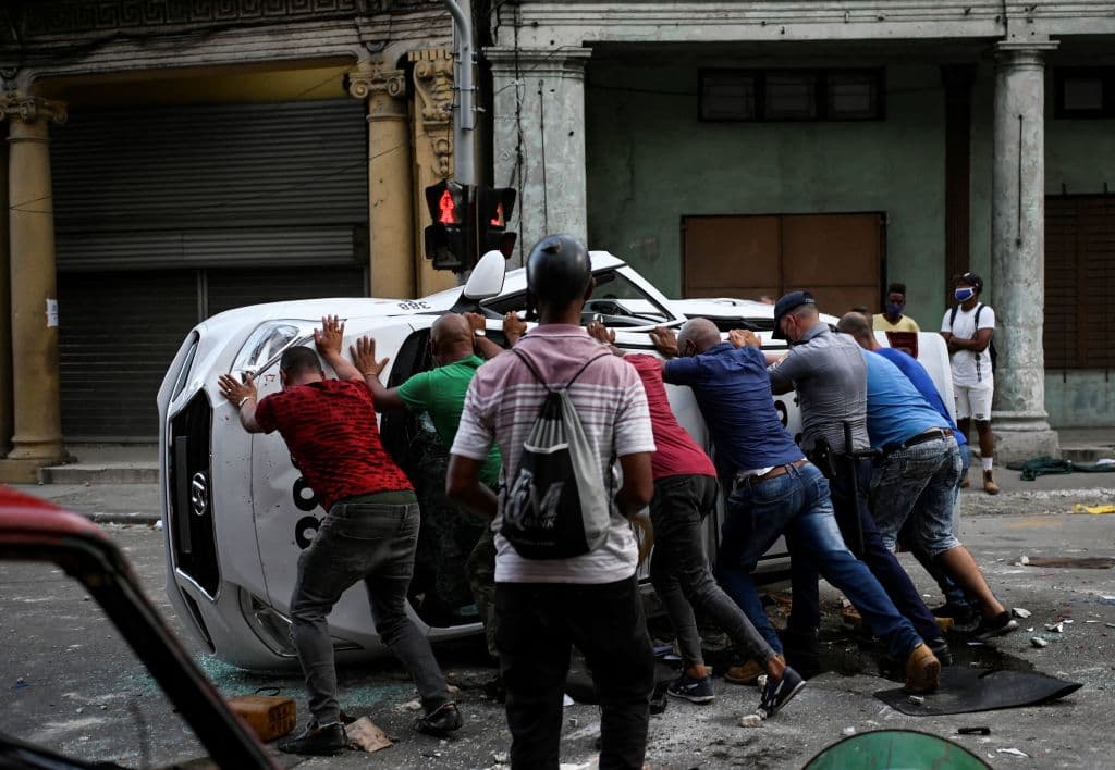 Un auto es volteado durante la jornada de protestas en la capital cubana.