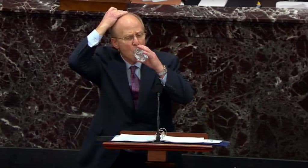 David Schoen se cubre la cabeza mientras toma un sorbo de agua en el pleno del Senado.