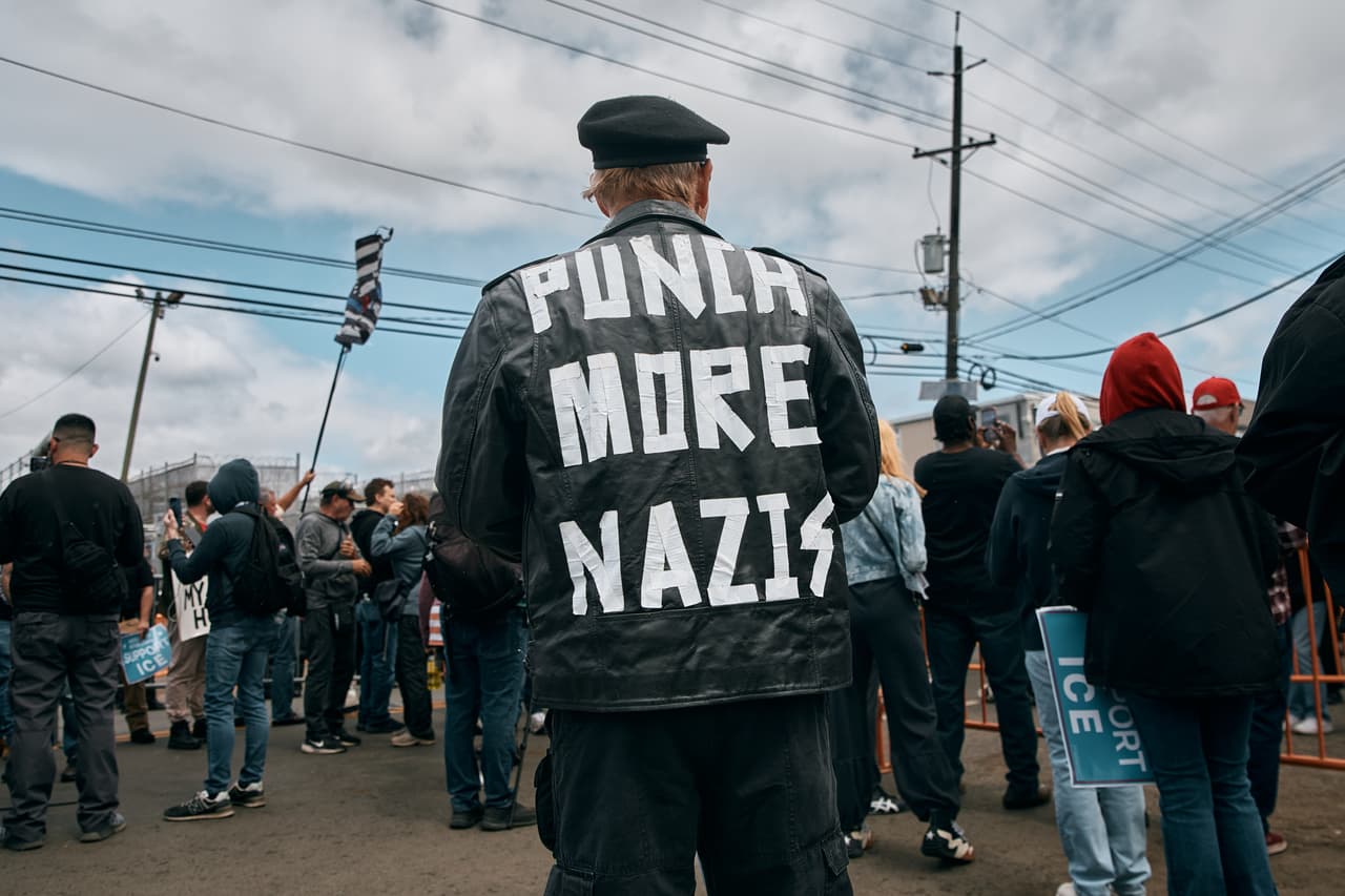 Un manifestante porta una chamarra con la frase “Punch More Nazis” (“Golpea más nazis”) durante una protesta frente al centro de detención Delaney Hall, en Newark, Nueva Jersey.