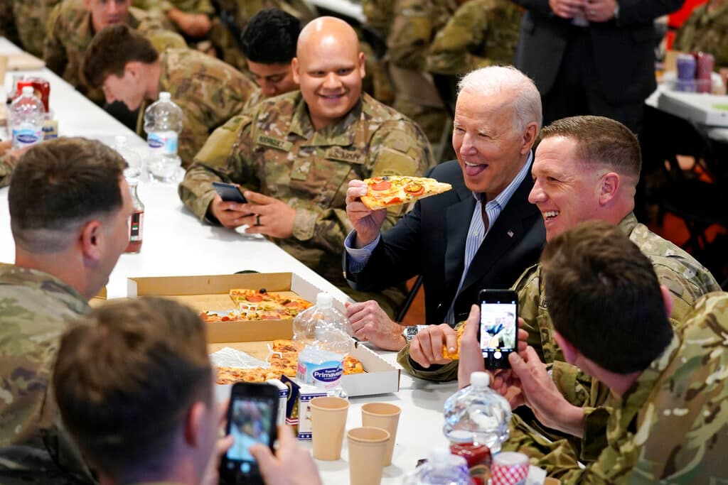 El presidente Biden comiendo pizza con los soldados estadounidenses en Polonia.