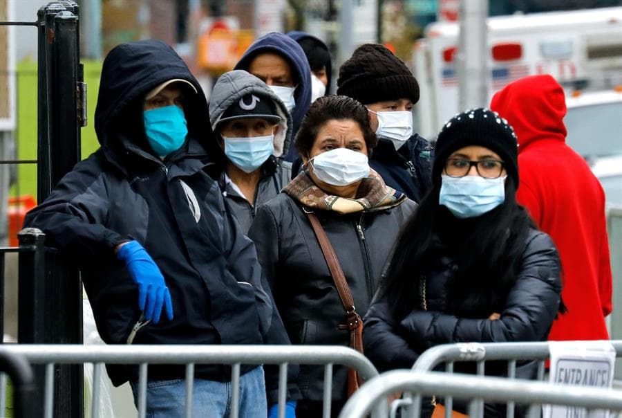 Personas usan máscaras protectoras a las afueras del Hospital Elmhurst de Queens, Nueva York.
<br>