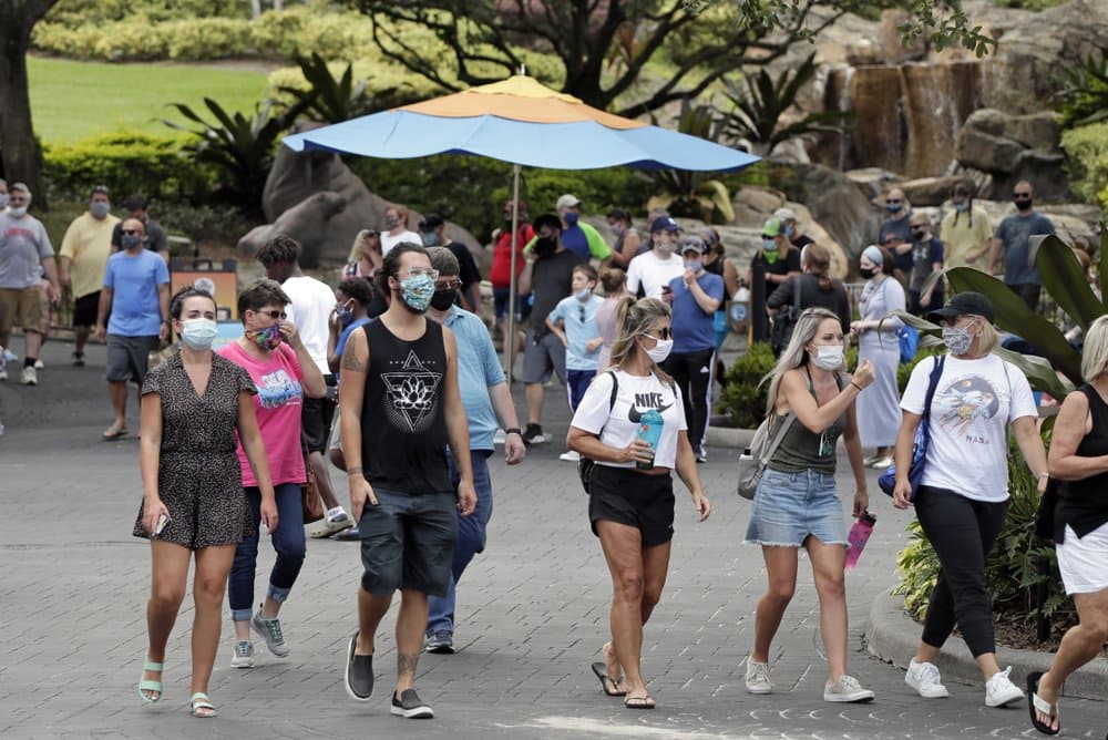 Personas usan máscaras mientras pasean por SeaWorld al reabrir con nuevas medidas de seguridad en Orlando, Florida.