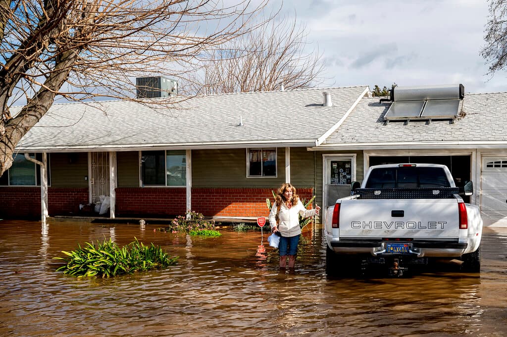 Kim Ochoa sale de su casa en Merced, rodeada de las aguas desbordadas del arroyo Bear que también anegó la vecina Planada, una pequeña comunidad agrícola situada junto a la carretera que conduce al Parque Nacional de Yosemite. Los residentes que recibieron la orden de evacuar cargaron con lo que pudieron salvar a sus espaldas mientras salían bajo la lluvia.