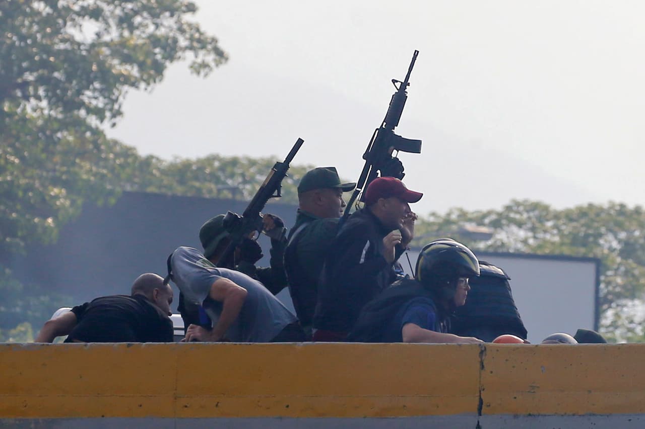 Tropas rebeldes que se alzan contra el régimen de Venezuela dispararon al aire sus armas desde un paso elevado fuera de la base aérea militar de La Carlota.