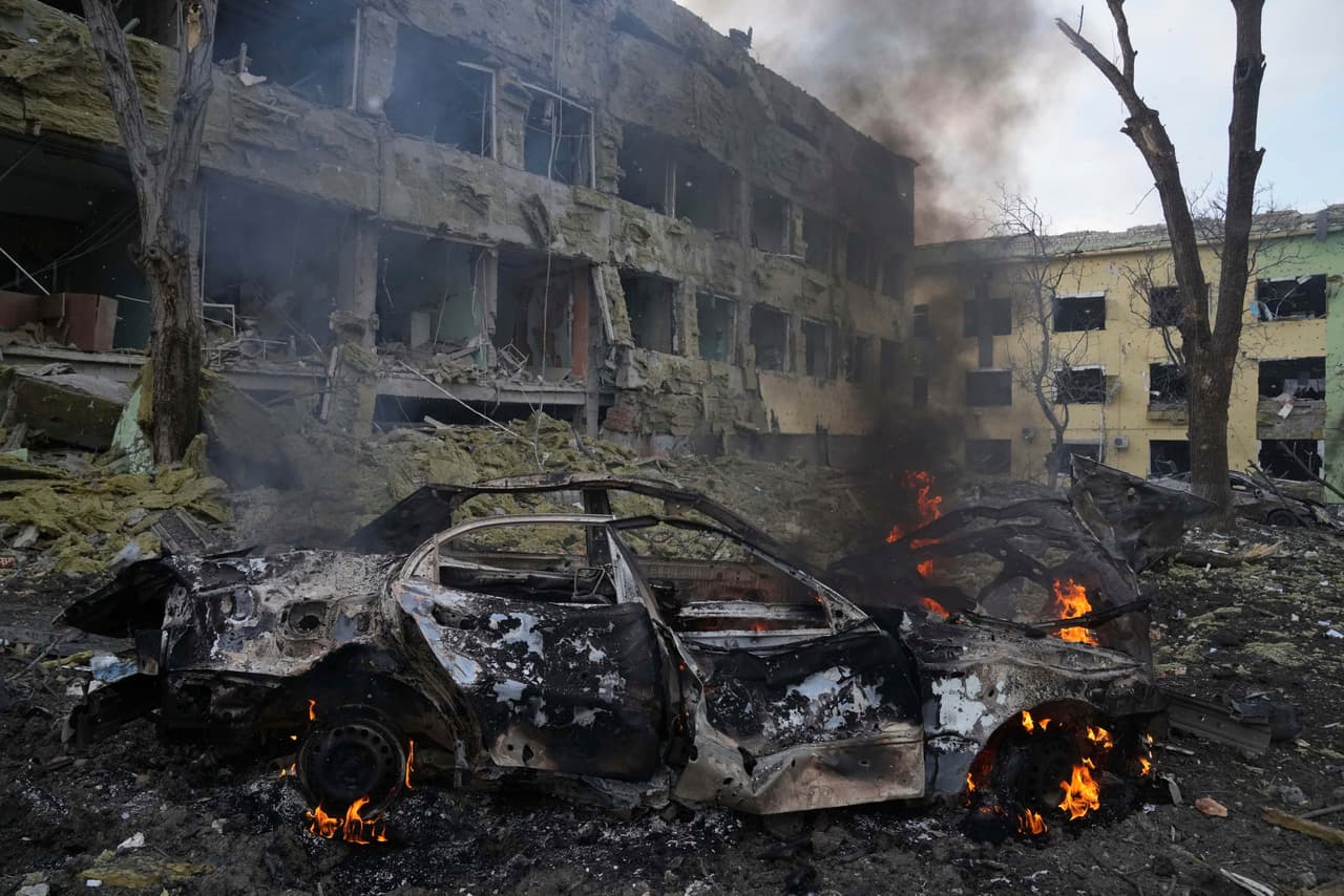 Un carro se quema frente al hospital materno infantil de Mariupol tras el bombardeo ruso.