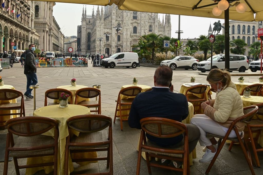 Una foto tomada en Milán el 20 de octubre de 2020 frente al Duomo muestra a la gente en un restaurante casi vacío. El gobierno de Italia ha obligado a usar protección facial al aire libre, en un intento de contrarrestar la propagación de la pandemia del coronavirus.