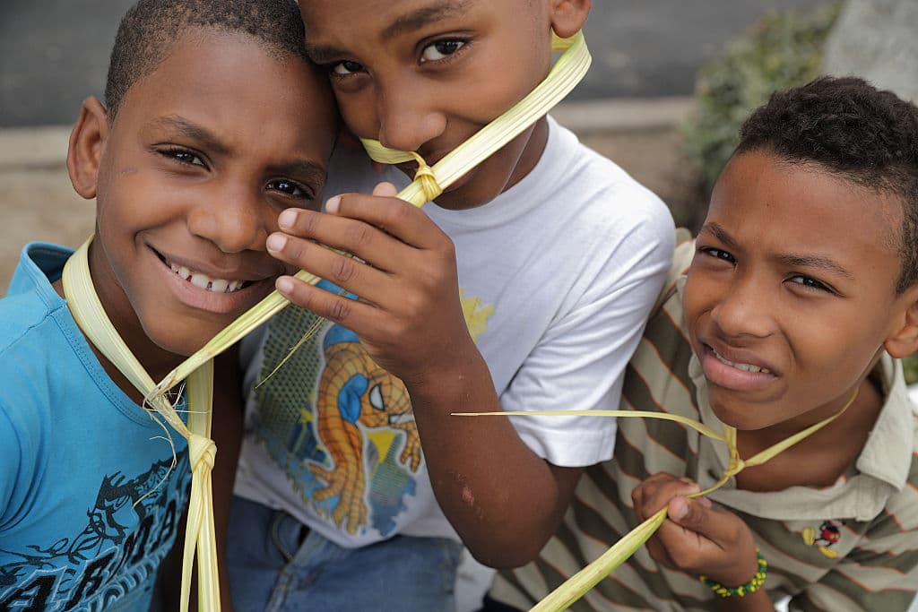 Tres niños cubanos sosteniendo sus palmas para ser bendecidas durante una misa de Domingo de Ramos en La Habana, 2016.