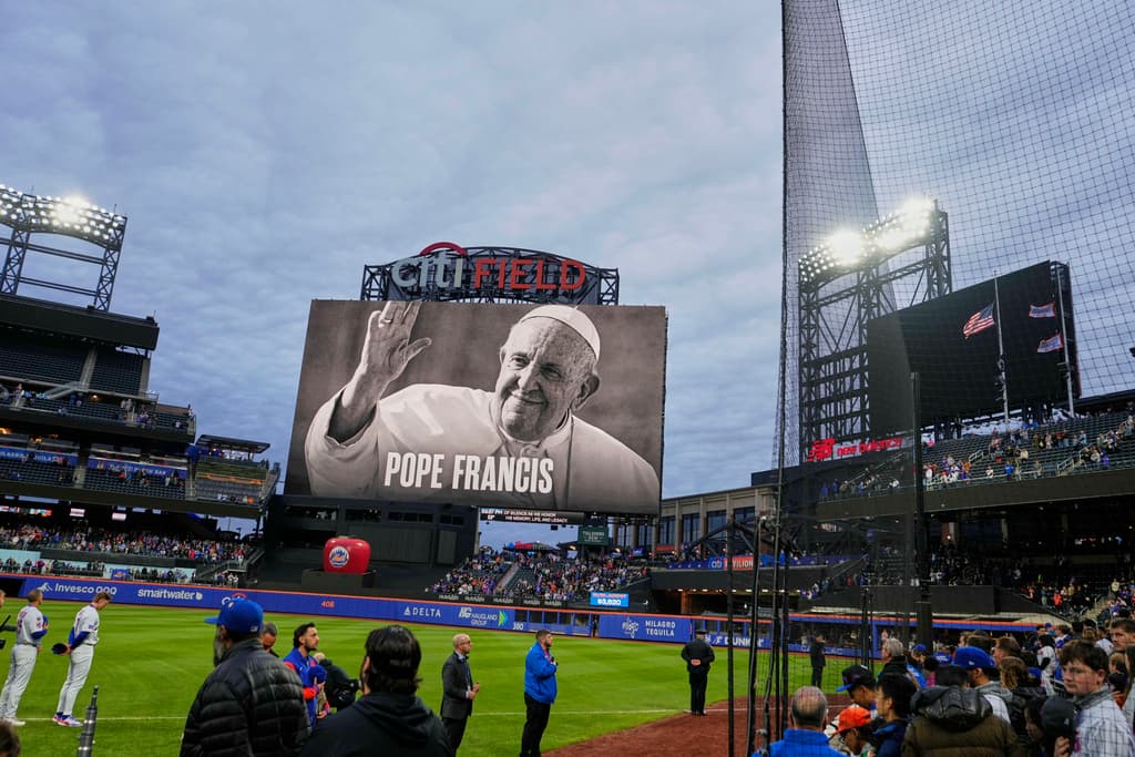 Aficionados y jugadores estuvieron de pie durante un momento de silencio mientras se mostraba un retrato del papa Francisco en el Citi Field antes de un partido de béisbol entre los Mets de Nueva York y los Phillies de Filadelfia el lunes 21 de abril de 2025, en Nueva York.