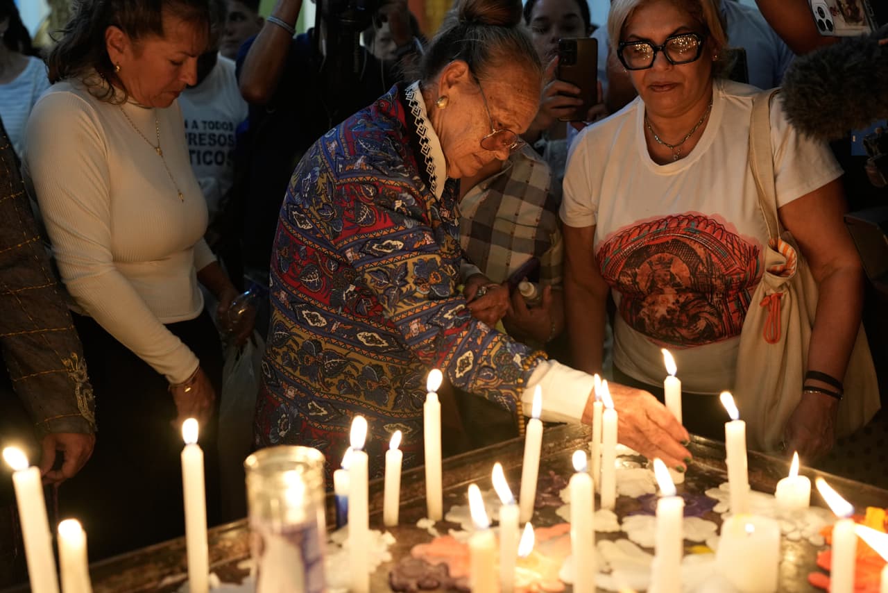 Carmen Navas enciende una vela en memoria de su hijo Víctor Quero, quien falleció bajo custodia en la prisión Rodeo I, durante una misa religiosa en su honor en Caracas, Venezuela, el viernes 15 de mayo de 2026. (Foto AP/Ariana Cubillos)