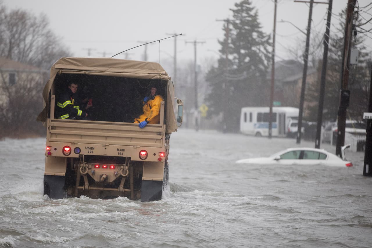 Un vehículo de la Guardia Nacional se acerca a zonas con residentes afectados por las inundaciones en Quincy, Massachusetts.