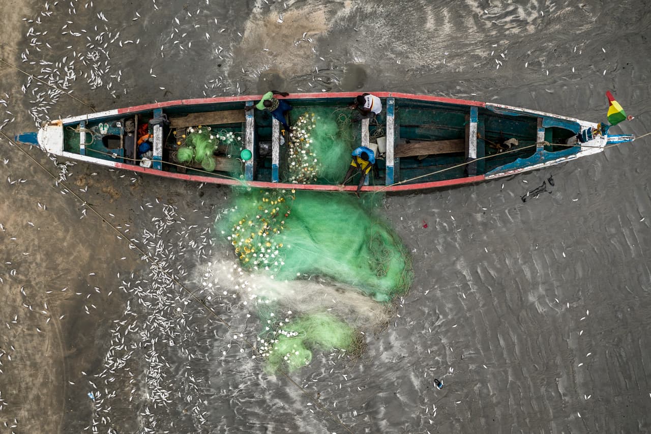 An aerial shot of a Gambian fishing boat with Gambian fishermen.