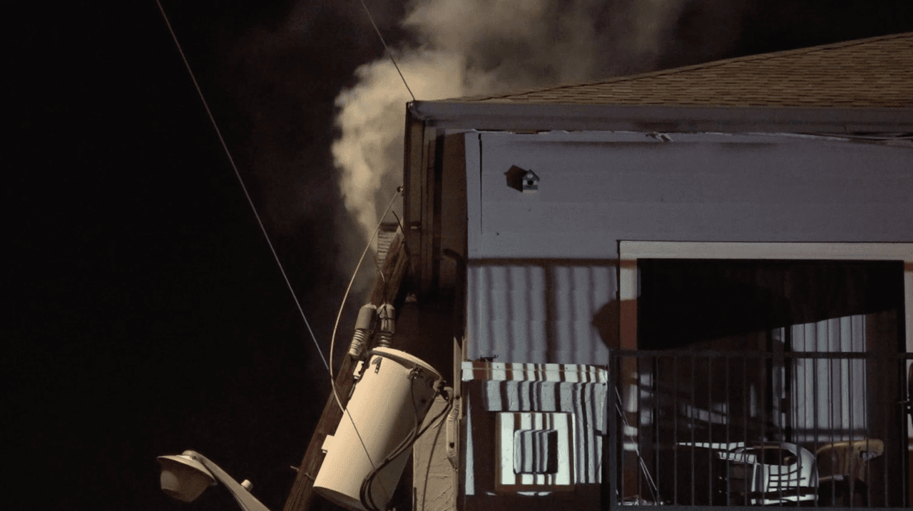 Cuando los bomberos llegaron al lugar, observaron un poste de electricidad apoyado contra el lado sur de un edificio de apartamentos de tres pisos.