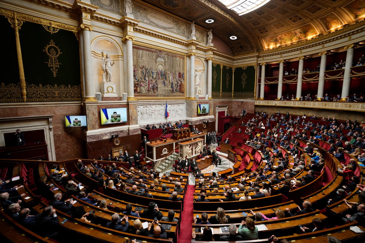 Ukrainian President Volodymyr Zelenskyy addresses Parliament Members in the French National Assembly, Wednesday, March 23, 2022 in Paris. Nearly one month has passed since the biggest land invasion in Europe since World War II, and there have been no major breakthroughs on the battlefield or the negotiating table. Russian forces appeared bogged down outside key cities in the face of fierce Ukrainian resistance (AP Photo/Francois Mori)