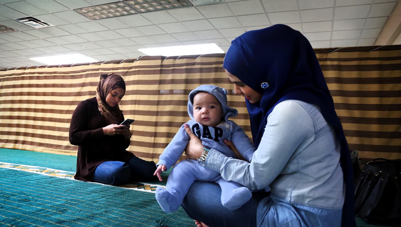 Aisha Figueroa, izq., y Eliana Francisco y su bebé Ayan en la mezquita de Bay Shore, Long Island, Nueva York, abril 14, 2016.