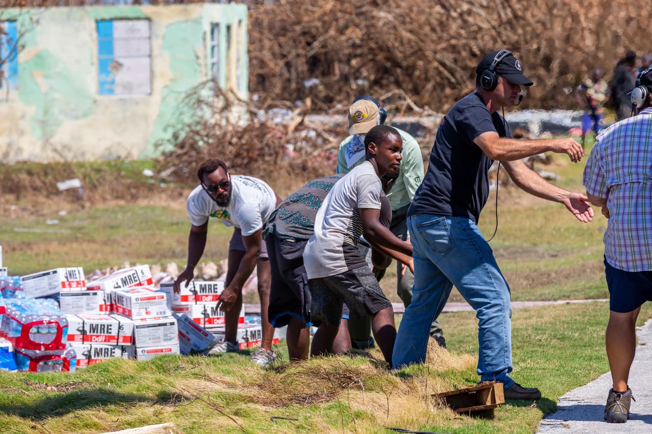 Habitantes locales que no pudieron huir de Dorian ayudan a repartir agua al resto de víctimas.