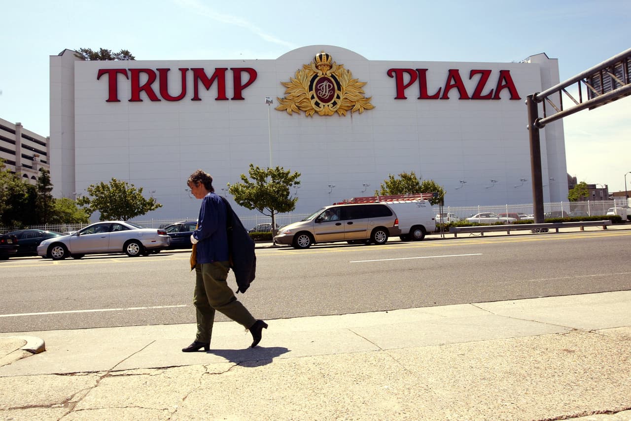 Una persona pasa al frente del casino Trump Plaza, el 1 de julio, 2003, en Atlantic City, Nueva Jersey. Ese año se inauguró un nuevo casino, el Borgata, una fuerte competencia para los casinos de Trump. El Borgata costó $1,000 millones, y contaba con 11 restaurantes y un spa de 50,000 pies cuadrados. Para esa época la ciudad ya estaba deprimida por la proliferación de casinos en otros estados del noreste. Foto: Spencer Platt/Getty Images.